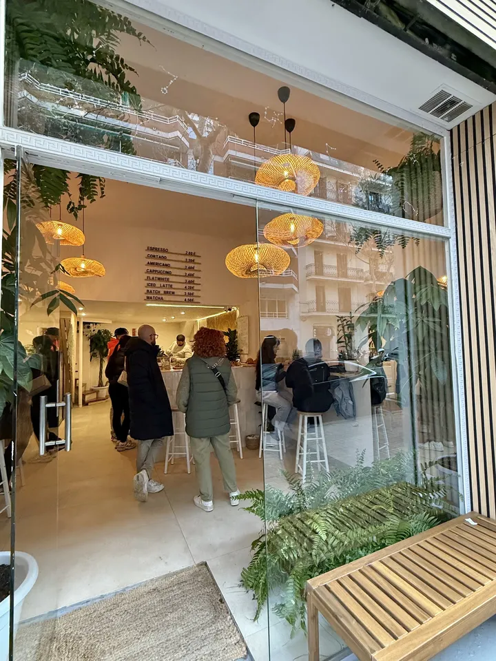 Entrada de HOROSCOFFEE en el Carrer del Rosselló, con clientes dentro